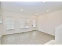Well-lit living room with wood floors, a back door, and multiple windows with bright white trim at 4209 Tifton Ln, Sugar Hill, GA 30518