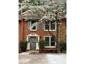 Beautiful brick townhome with lovely landscaping, and blooming tree enhancing curb appeal at 908 Chippendale Ln, Norcross, GA 30093