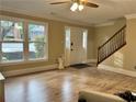 Bright living room featuring hardwood floors, staircase, and large windows offering natural light at 908 Chippendale Ln, Norcross, GA 30093