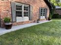 This image shows the lawn and lower part of the red brick house with decorative shutters at 2112 Fisher Ne Trl, Atlanta, GA 30345