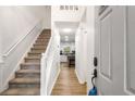 Inviting entryway with staircase, hardwood floors, and open view into the modern kitchen at 7275 Oswego Trl, Riverdale, GA 30296