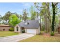Beautifully landscaped single-Gathering home with attached garage and a well-manicured front yard at 7275 Oswego Trl, Riverdale, GA 30296