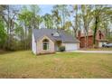 Beautiful single-Gathering home with a brick facade, an attached garage, and a well-maintained lawn at 7275 Oswego Trl, Riverdale, GA 30296