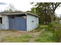 Side view of a light blue home showing an enclosed structure and a yard needing landscaping at 6232 Hospital Way, Douglasville, GA 30134