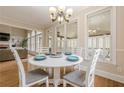 Cozy dining room featuring a white table, chandelier, and sunny windows at 7405 Richmond Way, Cumming, GA 30040