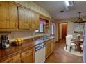 Traditional kitchen with wood cabinets, a stainless steel sink, and an adjacent dining area at 2140 Teri Ln, Conyers, GA 30013