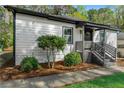 Close-up of the home's front entrance with updated siding, trimmed shrubs and walkway at 437 Collier Ridge Nw Dr, Atlanta, GA 30318