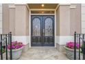 Close-up of a beautiful front door with decorative glass, stone walkway, and potted flowers at 7415 Northampton Ct, Cumming, GA 30040