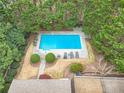 Aerial view of a private in-ground pool surrounded by mature trees and meticulously kept landscaping at 7415 Northampton Ct, Cumming, GA 30040