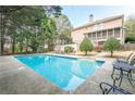 Backyard swimming pool with ample seating and a screened in porch of a two-story house at 7415 Northampton Ct, Cumming, GA 30040