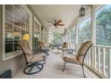 Cozy screened porch with comfortable seating and ceiling fans overlooking a serene outdoor setting at 7415 Northampton Ct, Cumming, GA 30040
