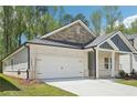 Inviting home exterior with brick siding, attached two-car garage and a well-kept lawn surrounded by mature trees at 3953 Brushy St, Powder Springs, GA 30127