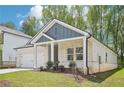 Well-maintained home with brick accents, a two-car garage, and manicured lawn featuring lush green grass and mature trees at 3953 Brushy St, Powder Springs, GA 30127