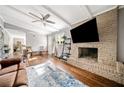 Cozy living room featuring a brick fireplace, hardwood floors, and ample natural light creating a warm atmosphere at 4595 Fradon Ct, Atlanta, GA 30349