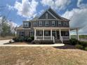 Stately two-story brick home with a welcoming front porch and fresh landscaping at 5458 Summer Pine Pl, Buford, GA 30518