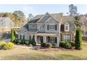 Beautiful two-story brick home with a covered porch, mature landscaping, and inviting curb appeal at 4535 Meadow Green Ln, Acworth, GA 30101