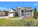 Beautiful home featuring stone accents, a well-maintained lawn, and an attached two car garage at 6793 Oconee Pl, Fairburn, GA 30213