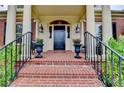 Charming front entrance with brick stairs, black railings, flower planters and large columns at 8070 Georgetown Cir, Suwanee, GA 30024