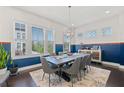 This dining room features a modern chandelier, large windows, and stylish furniture at 1388 La France Ne St, Atlanta, GA 30307