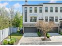 Townhome exterior featuring a brick and white facade, a two-car garage, and green front lawn at 1388 La France Ne St, Atlanta, GA 30307