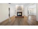 Spacious living room featuring a brick fireplace, wood floors, and neutral color scheme at 488 Takely Dr, Lawrenceville, GA 30046