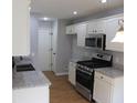 Updated kitchen features white cabinets, stainless steel appliances and granite countertops at 5815 Mountain Top Pl, Cumming, GA 30041