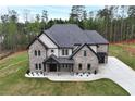 An aerial view of a charming two-story home featuring a brick facade and well-manicured lawn at 2107 E Maddox Rd, Buford, GA 30519