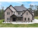 Charming two-story home featuring a brick facade, covered entrance, and well-manicured lawn at 2107 E Maddox Rd, Buford, GA 30519