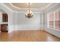 Elegant dining room featuring a stylish chandelier and beautiful hardwood floors at 295 Langshire Dr, Mcdonough, GA 30253