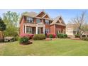 Charming brick home with a lush green lawn and vibrant flower beds at 295 Langshire Dr, Mcdonough, GA 30253