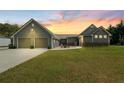 Charming exterior showcasing a two-car garage and manicured lawn at sunset at 111 Ayers Driver Rd, Villa Rica, GA 30180