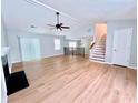 Spacious living room with hardwood floors, vaulted ceiling, ceiling fan, stairs, and entry door at 440 Sheppard Xing Ct, Stone Mountain, GA 30083