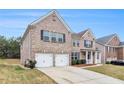 Attractive brick home featuring a spacious two-car garage, landscaped front yard and well-maintained lawn at 2036 Broadmoor Way, Fairburn, GA 30213