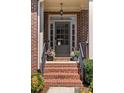 Inviting front entrance with a stylish gray door, brick steps, and decorative planters at 1662 Hartford Ne Gln, Atlanta, GA 30319