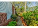 Landscaped side yard with a pathway leading to an archway and fenced area at 2972 Ponderosa Cir, Decatur, GA 30033
