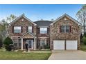 Two-story brick home with double garage, manicured lawn, and welcoming front entrance at 159 Molly Way, Mcdonough, GA 30253