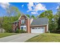 Two-story brick home with an attached two car garage and a long driveway at 3937 Sautee Trl, Conley, GA 30288