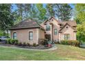 Attractive exterior view of stucco home with manicured lawn, mature trees, and curved sidewalk at 125 Russell Rd, Lawrenceville, GA 30043