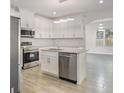Modern kitchen with stainless steel appliances, white cabinetry, granite countertops, and tile floors at 4066 Wild Orchid Ln, Loganville, GA 30052