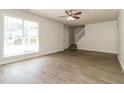 Open-concept living area with hardwood floors, a ceiling fan, and ample natural light from the large window at 4437 James Wade Dr, Snellville, GA 30039