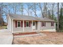 Ranch-style home featuring light siding and eye-catching red shutters, showcasing curb appeal at 5700 Tracy Dr, Mableton, GA 30126
