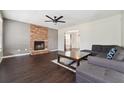 Cozy living room featuring a stone fireplace, dark wood floors, and a modern ceiling fan at 3380 Duncan Bridge Dr, Buford, GA 30519