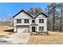 Charming two-story home featuring board and batten siding, black trim, and an attached garage at 400 Stone Lea Trce, Oxford, GA 30054