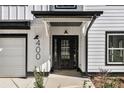 Close-up of front door with a black frame, decorative sidelights, and modern house numbers at 400 Stone Lea Trce, Oxford, GA 30054