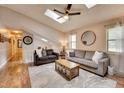 Bright living room with skylights, ceiling fan, hardwood floors, and large windows with decorative shades at 175 W Station Nw Dr, Kennesaw, GA 30144
