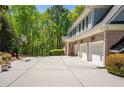Long driveway with a basketball hoop leading to a three car garage at 225 Ansley Close, Roswell, GA 30075