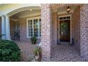 Charming brick front porch with a wooden door and decorative wreath at 225 Ansley Close, Roswell, GA 30075