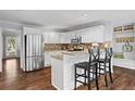 Bright kitchen featuring white cabinets, stainless steel appliances, granite countertops, and a breakfast bar at 3570 W Hampton Nw Dr, Marietta, GA 30064