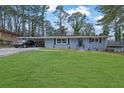 Beautiful home with blue painted brick, a spacious front lawn, and covered carport, perfect for suburban living at 3983 E Hilda Cir, Decatur, GA 30035