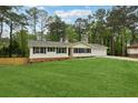 Well-maintained single-story home with expansive front lawn, mature trees, and dark shuttered windows at 756 Butler Ct, Lawrenceville, GA 30044